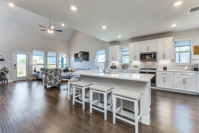 kitchen featuring stainless steel appliances, white cabinetry, tasteful backsplash, and dark hardwood / wood-style flooring