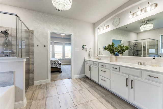 bathroom with vanity, separate shower and tub, and an inviting chandelier