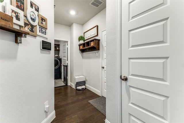 hallway with dark hardwood / wood-style floors and washer / dryer