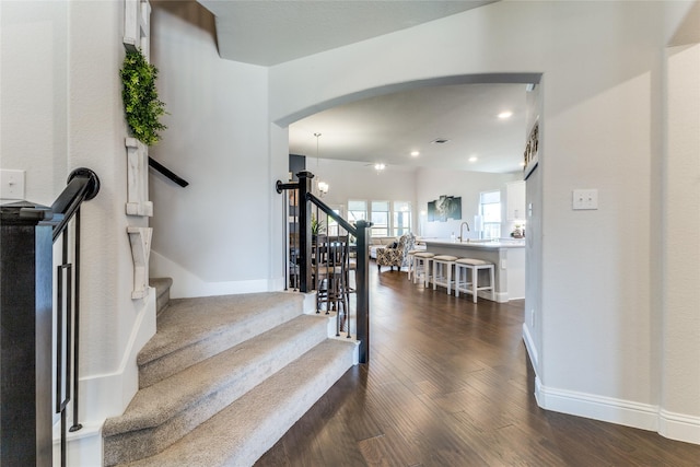 stairway with hardwood / wood-style flooring and sink