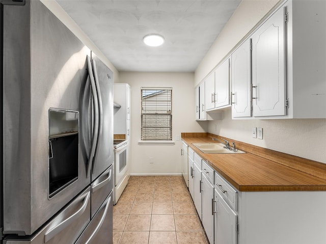 kitchen featuring light tile patterned flooring, sink, white cabinetry, stainless steel fridge, and electric stove