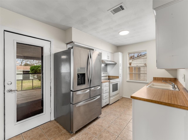 kitchen with white range with electric stovetop, white cabinetry, sink, light tile patterned floors, and stainless steel fridge with ice dispenser