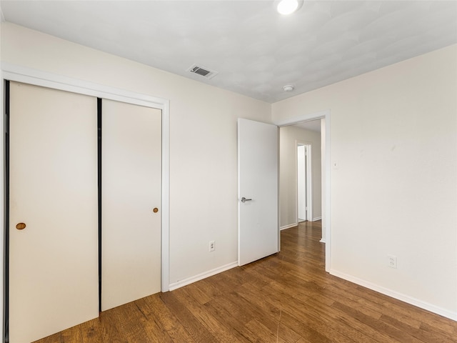 unfurnished bedroom featuring hardwood / wood-style floors and a closet