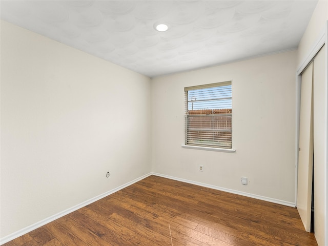 unfurnished bedroom featuring dark wood-type flooring and a closet