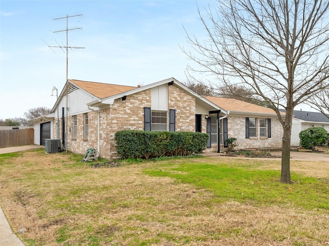 single story home with a garage, a front yard, and central air condition unit