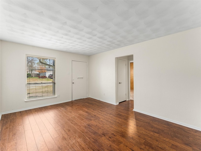 spare room with dark hardwood / wood-style flooring