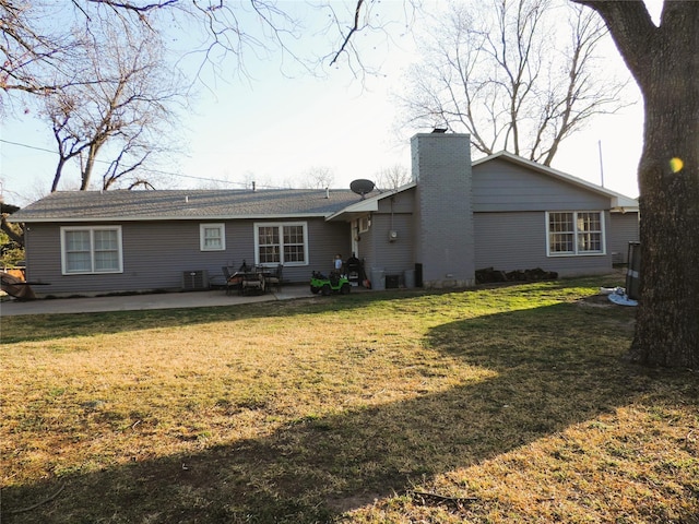 rear view of property with cooling unit, a yard, and a patio