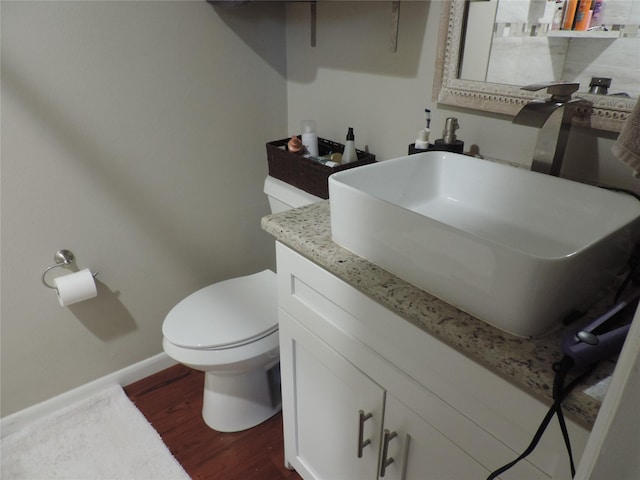 bathroom featuring vanity, wood-type flooring, and toilet