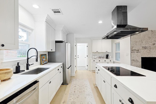 kitchen featuring island range hood, stainless steel appliances, sink, and white cabinets