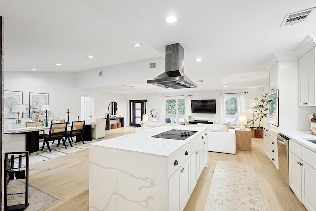 kitchen featuring light stone counters, a center island, appliances with stainless steel finishes, island exhaust hood, and white cabinets