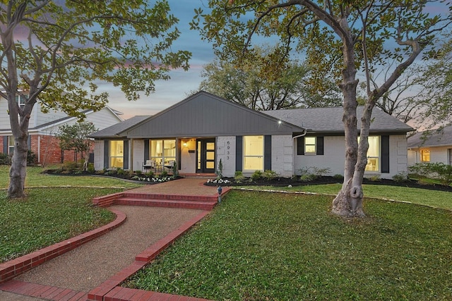 ranch-style home featuring a porch and a lawn