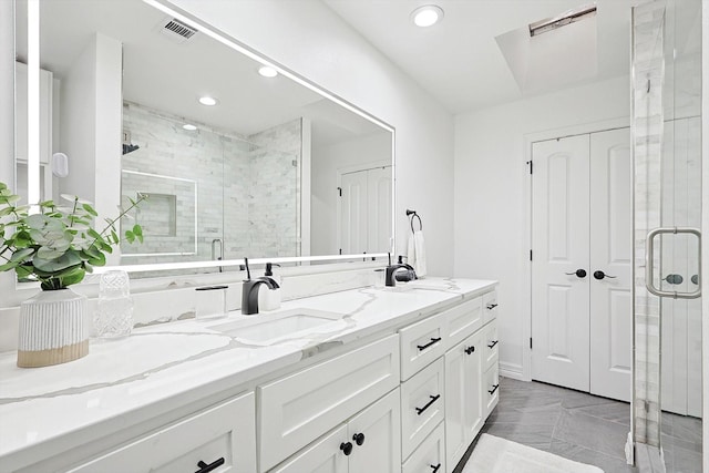 bathroom with a shower with door and vanity