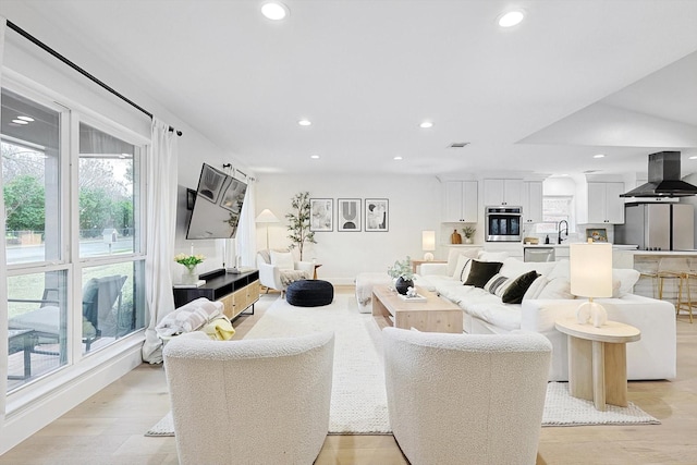 living room with sink and light hardwood / wood-style flooring