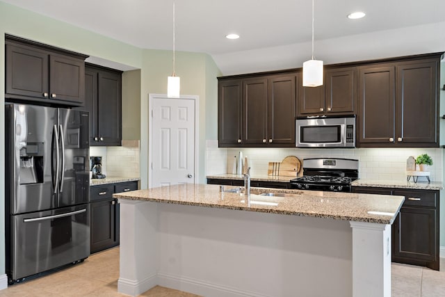 kitchen featuring light stone counters, a sink, dark brown cabinets, appliances with stainless steel finishes, and hanging light fixtures