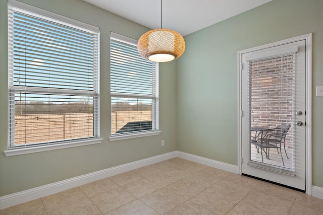 tiled empty room featuring baseboards