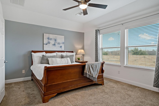 carpeted bedroom with a ceiling fan, visible vents, and baseboards