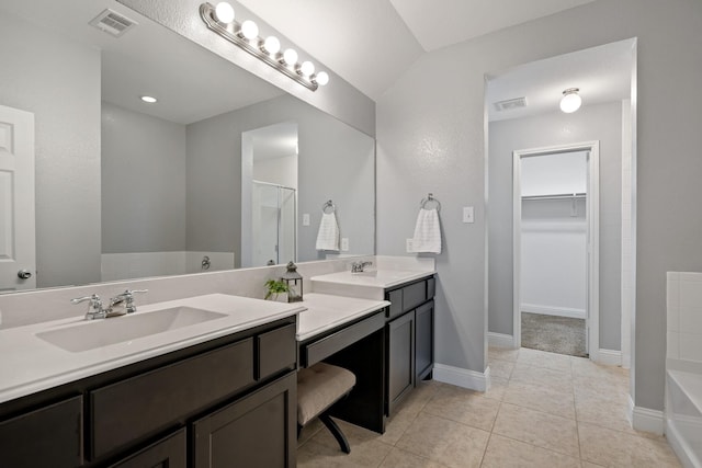 full bathroom featuring a tub to relax in, visible vents, two vanities, and a sink