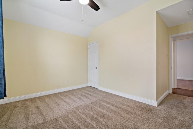 carpeted spare room with a ceiling fan, lofted ceiling, and baseboards