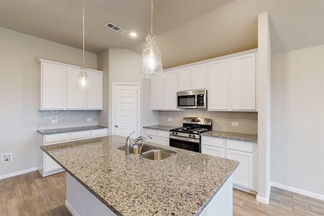 kitchen featuring sink, an island with sink, white cabinets, and appliances with stainless steel finishes