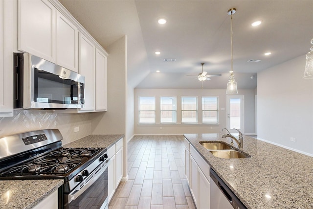 kitchen with light stone counters, appliances with stainless steel finishes, sink, and white cabinets