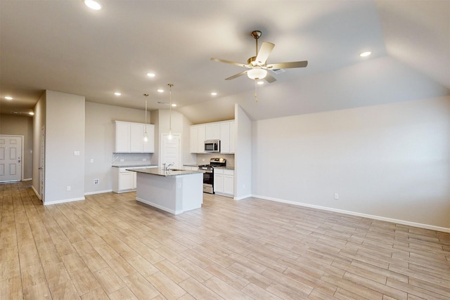 kitchen featuring white cabinetry, ceiling fan, stainless steel appliances, and a kitchen island with sink