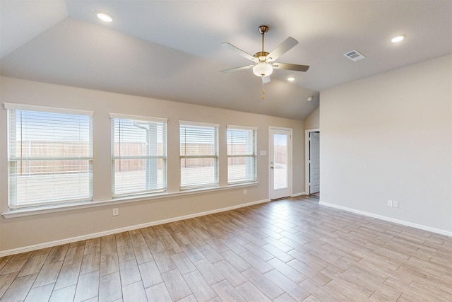 spare room with lofted ceiling, ceiling fan, a healthy amount of sunlight, and light wood-type flooring