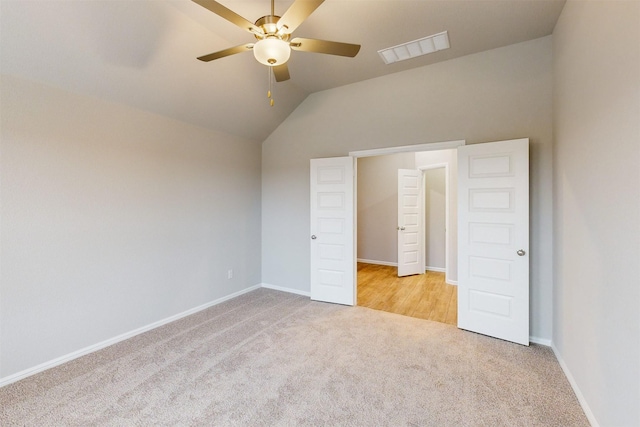 unfurnished bedroom featuring lofted ceiling, light colored carpet, and ceiling fan