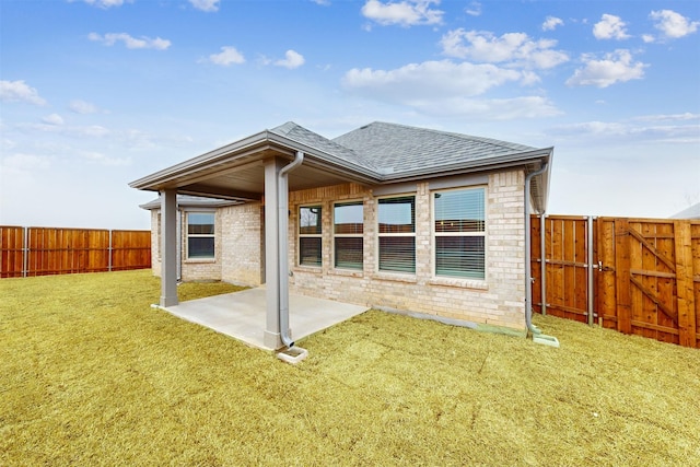 rear view of house featuring a yard and a patio area