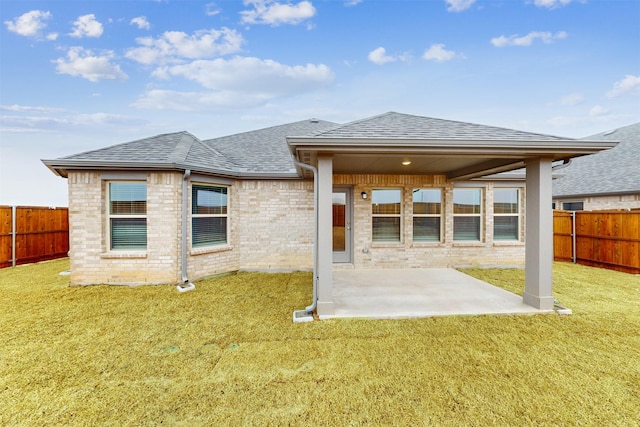 rear view of house featuring a patio and a lawn