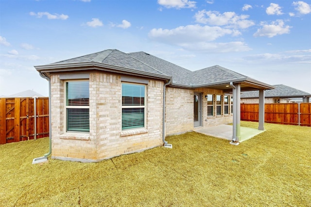 back of house featuring a yard and a patio