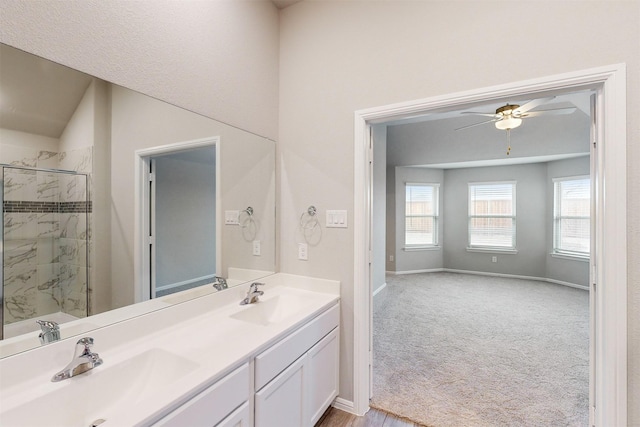 bathroom with vanity, ceiling fan, and a tile shower