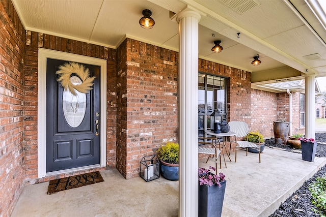 view of exterior entry featuring covered porch