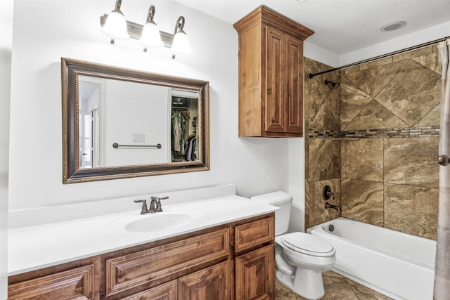 full bathroom featuring tiled shower / bath, vanity, and toilet