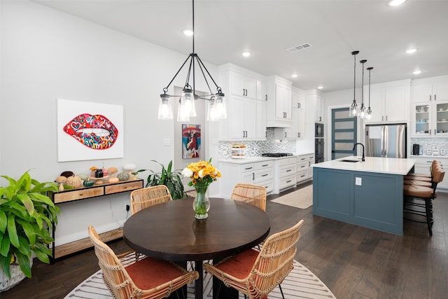 dining area featuring dark wood-type flooring, a chandelier, and sink