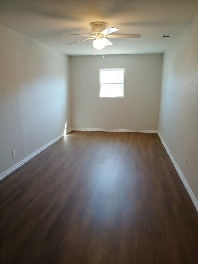 empty room featuring dark hardwood / wood-style flooring and ceiling fan