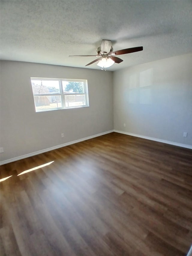 empty room with ceiling fan, dark hardwood / wood-style floors, and a textured ceiling