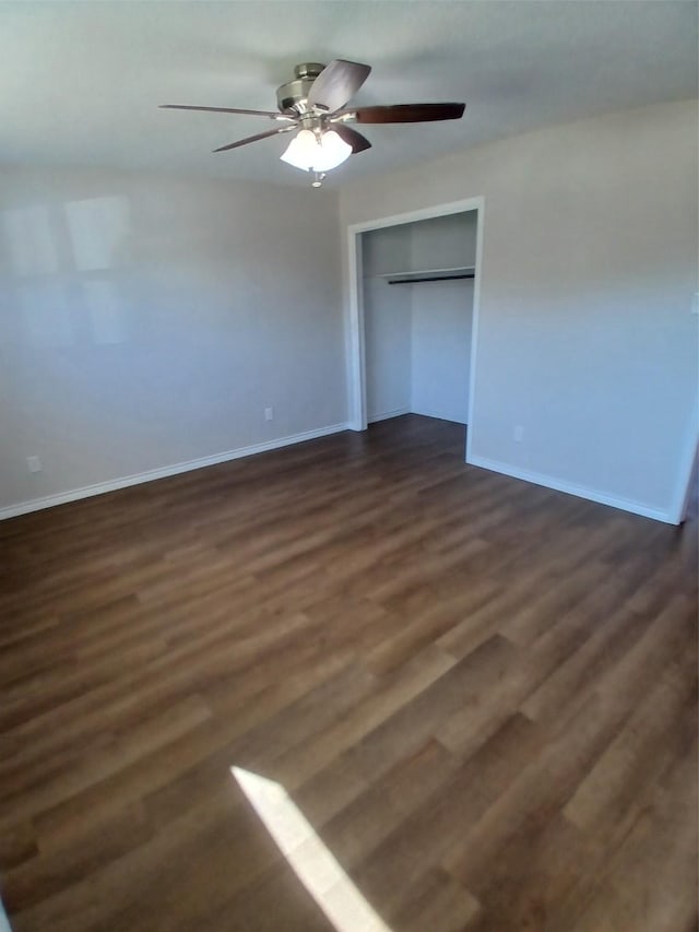 unfurnished bedroom featuring dark hardwood / wood-style flooring, a closet, and ceiling fan