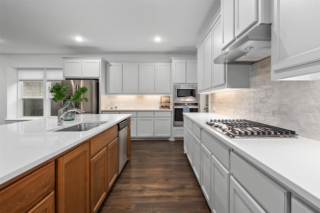 kitchen featuring sink, white cabinets, backsplash, stainless steel appliances, and dark wood-type flooring