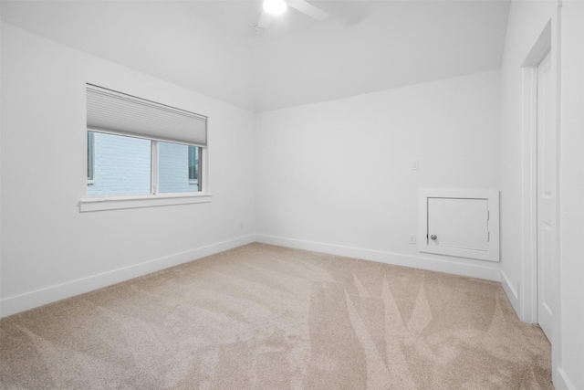 carpeted empty room featuring ceiling fan and vaulted ceiling