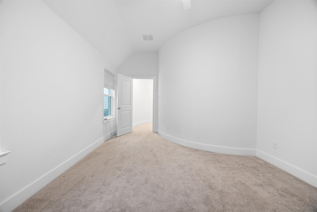 empty room featuring vaulted ceiling and carpet flooring