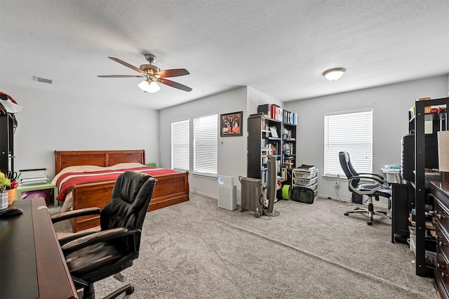 home office featuring ceiling fan, plenty of natural light, carpet, and a textured ceiling