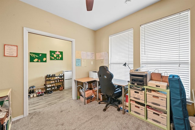 office area featuring light carpet and ceiling fan