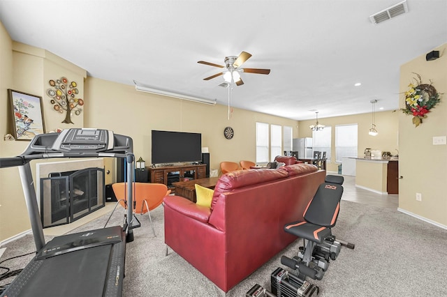 carpeted living room with ceiling fan