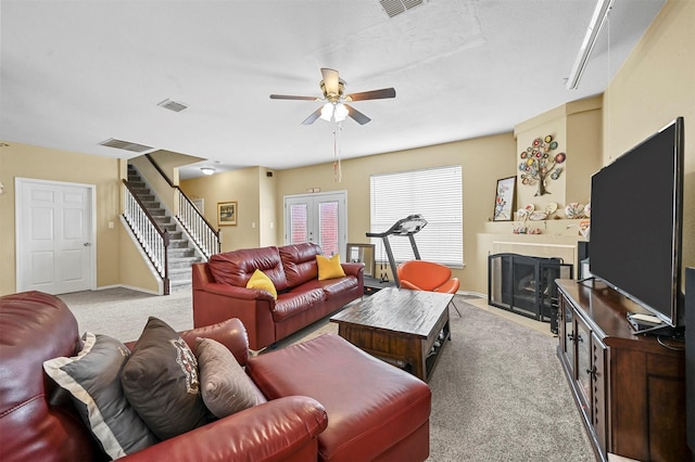 living room with french doors, ceiling fan, and light carpet