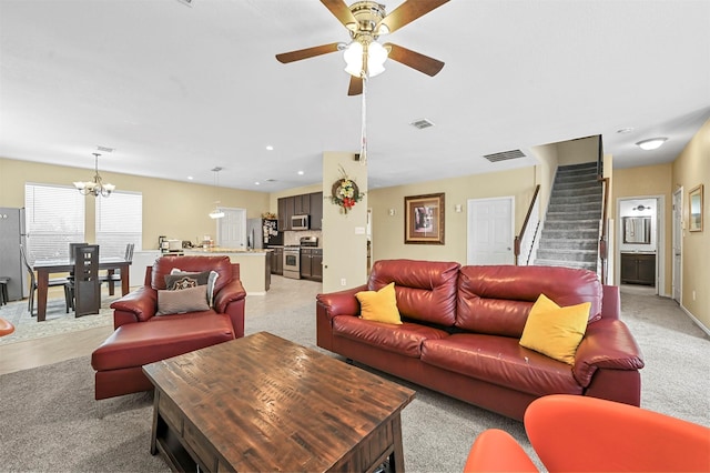 living room with ceiling fan with notable chandelier