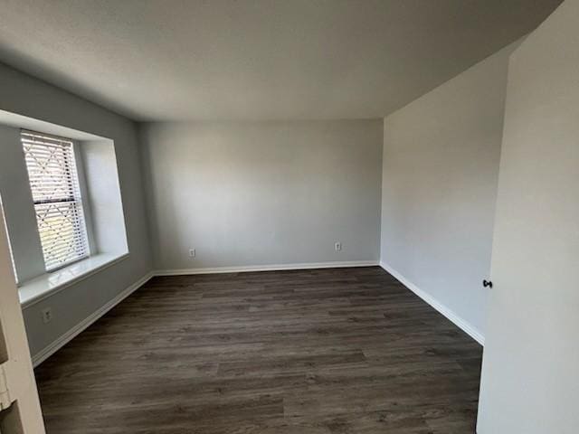 unfurnished room with dark wood-type flooring