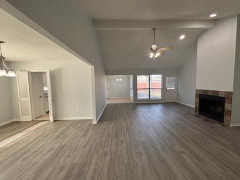 unfurnished living room with beamed ceiling, dark hardwood / wood-style floors, ceiling fan with notable chandelier, and a tile fireplace