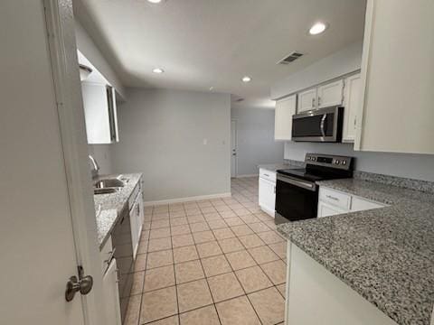 kitchen featuring sink, white cabinetry, light tile patterned floors, stainless steel appliances, and light stone countertops