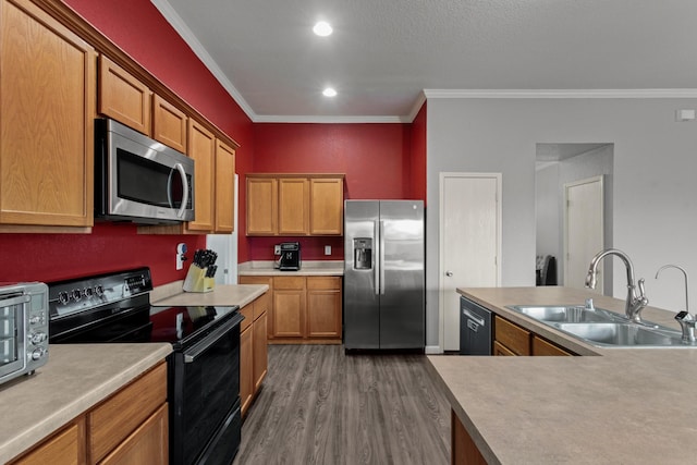 kitchen with crown molding, dark hardwood / wood-style flooring, sink, and black appliances