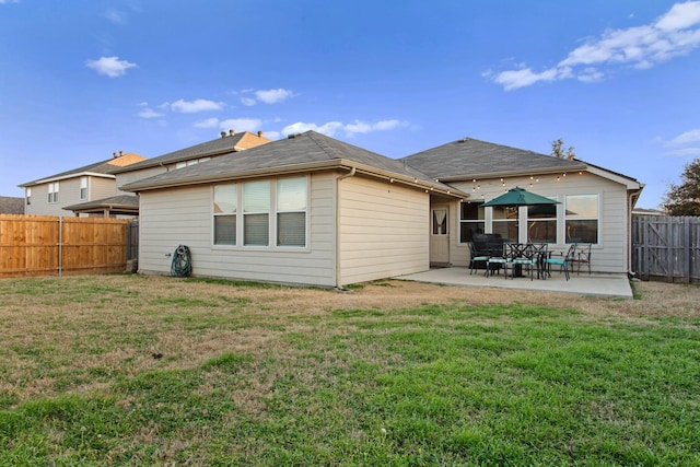 rear view of property featuring a patio area and a lawn